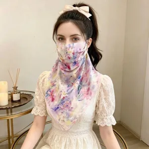 Detailed view of floral silk sunscreen face mask and neck scarf worn by a model