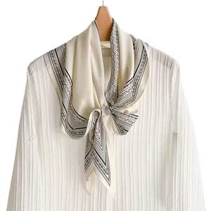Elegant vintage cream silk scarf featuring a black paisley pattern tied on a white shirt