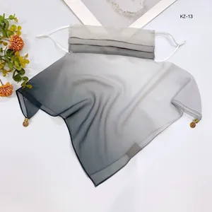 Detail view of gradient grey sun protection face mask veil with decorative charms