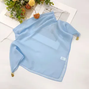 Close-up view of a light blue chiffon sun protection face mask scarf with gold charms
