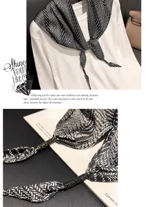 Macro detail of black patterned silk triangle scarf showing elegant fabric texture
