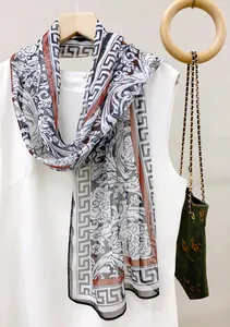 Detail view of high-end silk scarf with Greek key border and floral pattern, 35x140cm