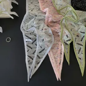 Dettaglio di bandane triangolari leggere in pizzo floreale in vari colori tenui.