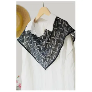 Sciarpa triangolare in pizzo nero con paillettes su camicia bianca vista