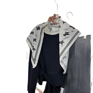 Foulard triangulaire en soie blanche avec imprimé cheval noir élégant et bordure rayée.