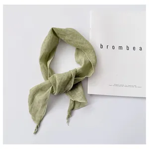 Detail view of minimalist light green ramie neck scarf showing natural linen texture