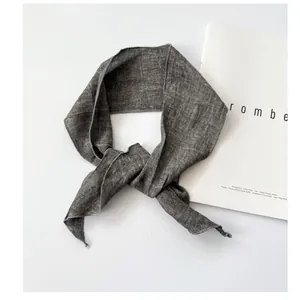 Detail view of a gray ramie skinny scarf with natural linen texture on a white background