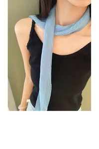 Close-up detail of a light blue pleated skinny neck scarf worn elegantly on a female model.
