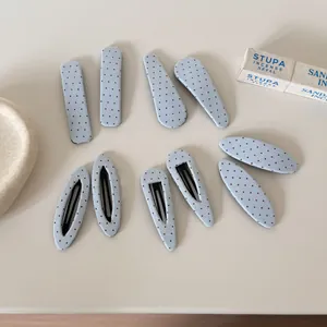 Gedetailleerd overzicht van blauwe stoffen haarklemmen met rode stippen op een lichte basis