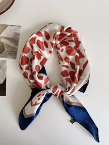 Dettaglio di un foulard quadrato con stampa leopardata ruggine e bordi blu scuro