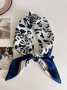 Dettaglio di un foulard quadrato in seta con stampa leopardata e eleganti bordi blu