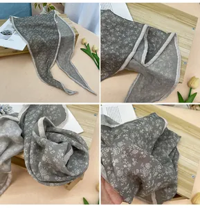 Primer plano detallado de bufanda floral gris que muestra la textura de la tela y el estampado