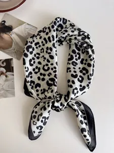 Dettaglio di un elegante foulard quadrato in seta con stampa leopardata annodato a nodo