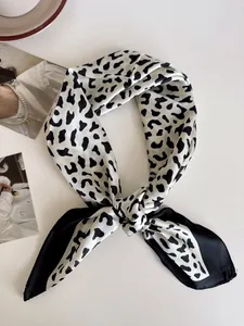 Primo piano di un foulard di seta zebrato bianco e nero annodato in modo molto chic