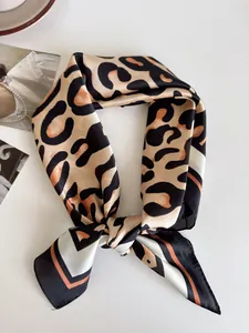 Primo piano di un elegante foulard di seta a macchie di leopardo con bordi neri e arancio