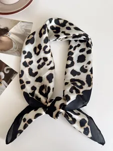 Primo piano di un piccolo foulard quadrato alla moda con stampa leopardata e un nodo.