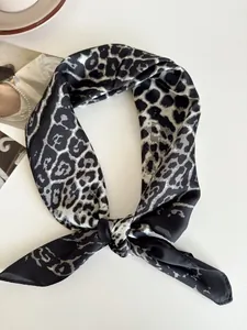 Dettaglio della trama annodata e della stampa leopardata nera del setoso foulard da collo.