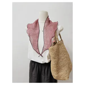 Dettaglio del foulard a triangolo in lino stile Mori a scacchi su manichino.