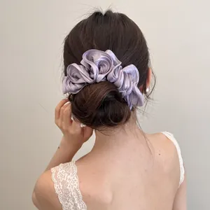 Grote lavendel satijnen scrunchie met ruches voor een elegant opgestoken kapsel.
