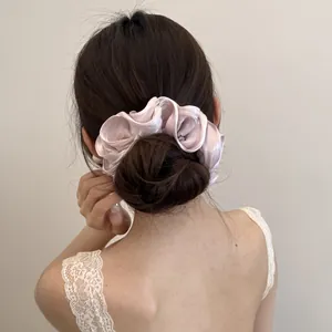 Gedetailleerd achteraanzicht van een satijnen scrunchie op een stijlvolle haarknot