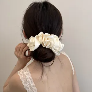 Elegante oversized parelachtige satijnen scrunchie op een lage knot voor een chique look