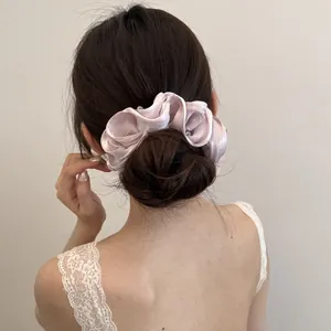 Gedetailleerde weergave van een lichtpaarse satijnen scrunchie op een haarknotje