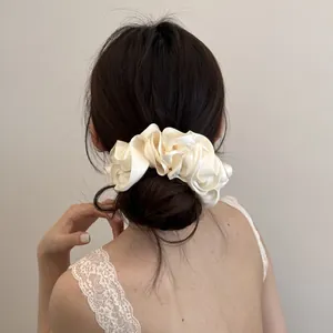 Gedetailleerd achteraanzicht van een vrouw met een crème satijnen scrunchie in haar knot