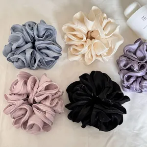 Grote parelmoerglanzende satijnen scrunchies in verschillende zeer elegante kleuren.