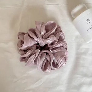 Detail van de gelaagde parelmoer satijnen textuur van de paarse oversized scrunchie
