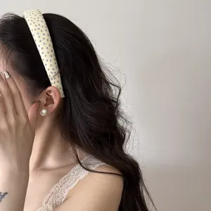 Detailopname van een gele stoffen haarband met stippen in Koreaanse stijl