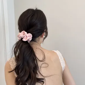 Détail d'un chouchou à pois roses utilisé pour une coiffure élégante en queue de cheval