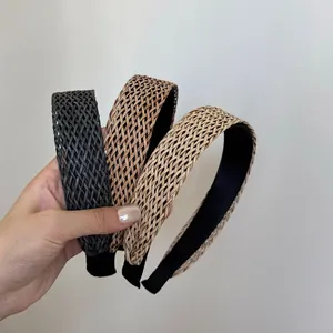 Vue rapprochée de trois serre-têtes tressés en noir, marron et beige de style bohème