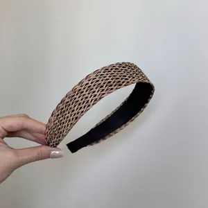 Vue détaillée de la texture tressée en paille de ce large serre-tête bohème marron.