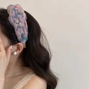 Vue détaillée du serre-tête tressé en gaze aux couleurs dégradées porté par un mannequin.