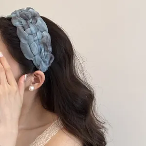 Détail du serre-tête tressé en gaze bleue tie-dye pour une coiffure quotidienne élégante.
