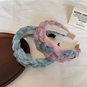 Détail de serre-têtes en organza tressé avec d'élégants dégradés de couleurs pastel