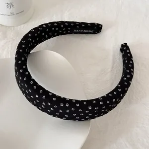 Detail van zwarte gaas hoofdband met witte stippen en een handgemaakt label erop