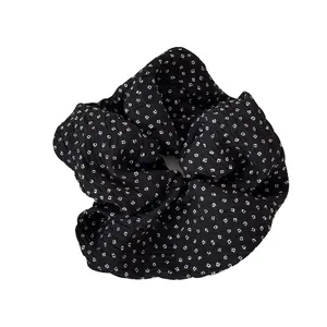 Elegante zwarte gaas scrunchie met wit bloemenpatroon en een stijlvol geplooid ontwerp