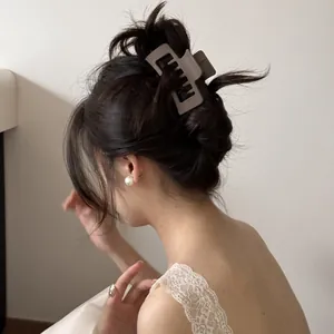 Detailed view of a large matte hair claw clip holding a bun in place