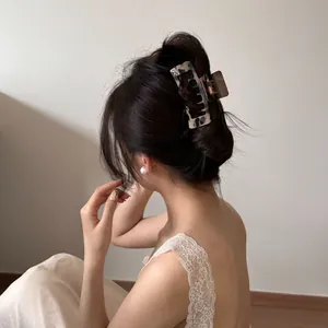 Back view of a high-quality large leopard print hair claw clip securing a stylish bun