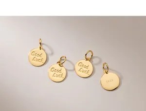 Dettaglio macro di ciondoli tondi in argento S925 placcato oro con scritta Good Luck