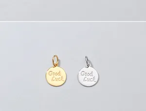 Vista dettagliata dei ciondoli tondi 'Good Luck' in argento S925, finiture oro e argento