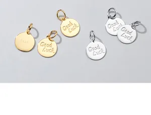 Vista dettagliata di ciondoli tondi in argento sterling S925 con messaggio Good Luck inciso