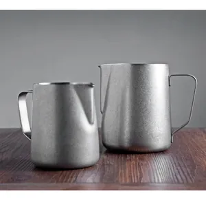 Detail view of two 304 stainless steel milk frothing pitchers with pointed spouts