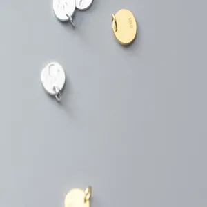 Close-up of S925 sterling silver palm and footprint charms in gold and silver colors