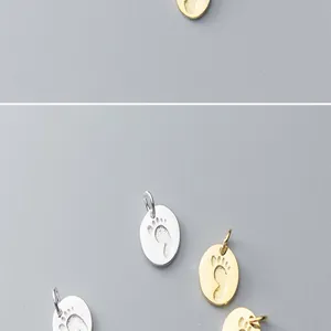 Close-up of S925 silver and gold-plated footprint charms for DIY jewelry accessories