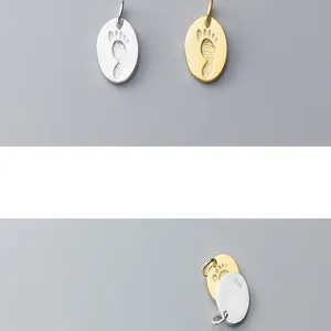 Close-up of S925 silver footprint pendant charms showing front and back detail views.