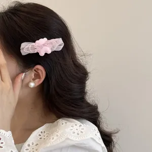 Primer plano de una pinza para el pelo de tul rosa con oso, lucida por una modelo joven.