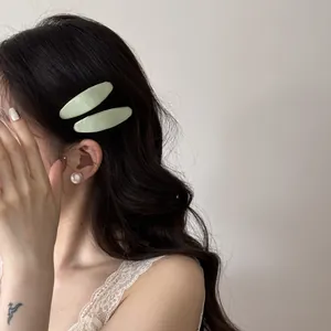 Gros plan détaillé d'un mannequin portant des barrettes en tissu vert sur cheveux ondulés