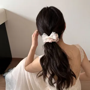 Rückansicht eines Modells mit einem eleganten rosa Haargummi mit Satinschleife